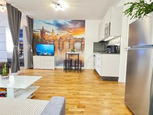 uma sala de estar com uma cozinha e uma televisão em New modern-style apartment with balcony in the Prague 2 em Praga