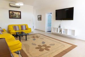 卡斯特利翁－德拉普拉納的住宿－Casa Moderna cerca de la PLAYA，客厅配有黄色椅子和平面电视