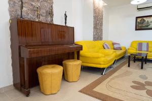 sala de estar con piano y sofá amarillo en Casa Moderna cerca de la PLAYA, en Castellón de la Plana