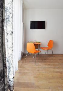 a dining room with orange chairs and a table at Chez Alycelia - Studio - Orly - Gare - 25' Paris centre in Juvisy-sur-Orge