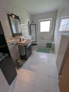 een badkamer met een wastafel, een toilet en een spiegel bij ApartmentLochbrücke in Meckenbeuren