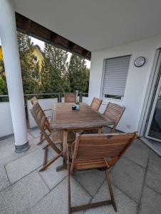 een houten tafel en stoelen op een patio bij ApartmentLochbrücke in Meckenbeuren