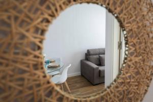 espejo que refleja una sala de estar con mesa y sofá en Apartamento Carmela, en Monachil