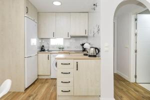 cocina blanca con armarios blancos y nevera en Apartamento Carmela, en Monachil