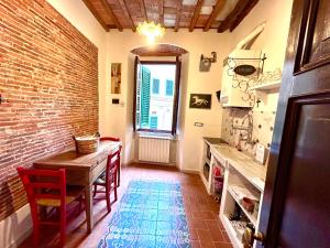 カッラーラにあるLa Porta sui Monti di Lunaのレンガの壁、テーブル付きのキッチン
