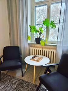 uma sala de estar com duas cadeiras e um tabuleiro de xadrez sobre uma mesa em Hostel Bjorkenheim em Seinäjoki