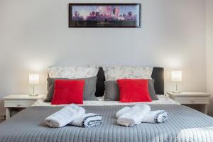 um quarto com uma cama com almofadas vermelhas e brancas em Centre Palais des Papes-Balcon B1 Clim - 123avignon em Avignon