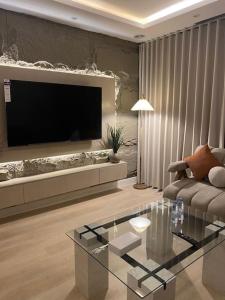 a living room with a large flat screen tv at شقة مريحة بتصميم انيق ودخول ذكي in Riyadh