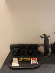 a tray with cups and a coffee maker on a table at شقة مريحة بتصميم انيق ودخول ذكي in Riyadh