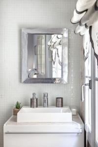 bagno con lavandino bianco e specchio di Centre Palais des Papes-Balcon B1 Clim - 123avignon ad Avignone