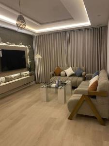 a living room with a couch and a table at شقة مريحة بتصميم انيق ودخول ذكي in Riyadh
