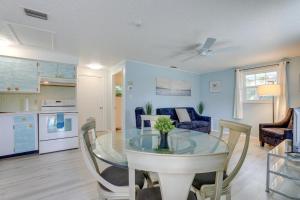 comedor y cocina con mesa de cristal y sillas en Englewood Apartment with Shared Pool 1 Mi to Beach en Englewood
