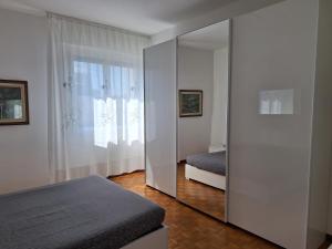 a mirror in a bedroom with a bed and a window at King 35 in Bologna