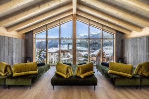 een woonkamer met banken en een groot raam bij Hotel Ravelli Luxury Spa in Mezzana