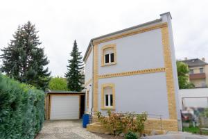 Casa blanca con 2 grandes puertas blancas de garaje en Business-Apartment, en Leipzig