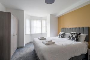 Modern 3 Bedroom Apt near City Centre Parking included في بلفاست: غرفة نوم بسرير كبير عليها منشفتين