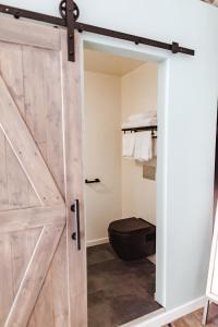 uma porta deslizante de celeiro numa casa de banho com WC em Tammah Jackson Hole em Wilson