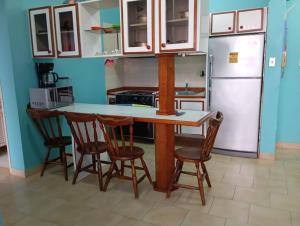 a kitchen with a table and chairs and a refrigerator at Desarrollo Turístico Punta Brava Tucacas Morrocoy in Tucacas