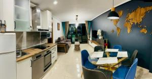 a kitchen with a table and a blue wall at Marin Beach Apartments Patacona in Valencia