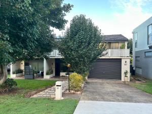 a house with a garage and a driveway at Fi's Beach Pad in Port Macquarie