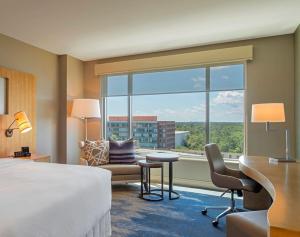 a hotel room with a bed and a desk and a window at The Westin at The Woodlands in The Woodlands