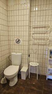 a white bathroom with a toilet and a stool at Chocolate Hostel in Kaunas