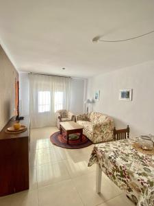 a living room with a couch and a table at Bungalow Steps from Moraira in Teulada