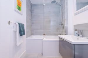 a white bathroom with a shower and a sink at Number 21: A Breathtaking Chester Cottage with Parking in Mollington +34 photos