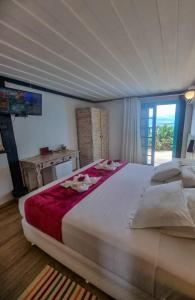 a large white bed in a bedroom with a window at Vila Bela-Emília in Búzios