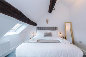 a bedroom with a large white bed in a attic at Number 21: A Breathtaking Chester Cottage with Parking in Mollington