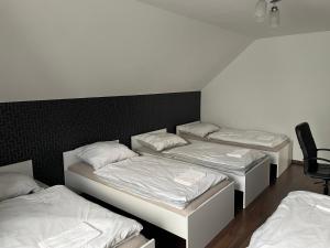 three beds in a room with white sheets at MiiG Residence Jacuzzi & Sauna Zator Oświęcim in Oświęcim