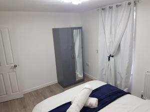 a bedroom with a bed with a mirror and a window at Holiday Let - Entire modern home in Medway in Gillingham