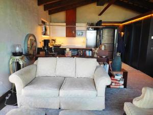 a living room with a white couch and a kitchen at Masía La Garrotxa in Olot