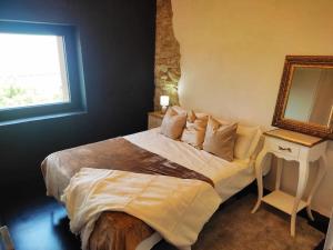 Schlafzimmer mit einem Bett mit einem Spiegel und einem Fenster in der Unterkunft Masía La Garrotxa in Olot