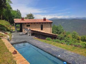 a house with a swimming pool in front of it at Masía La Garrotxa in Olot