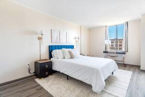 a white bedroom with a large bed and a desk at Hartford Cityscape Bushnell Park Downtown Skyline in Hartford
