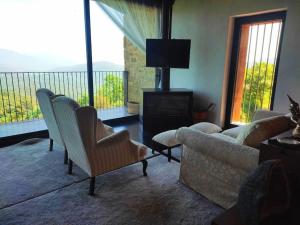 a living room with a couch and chairs and a balcony at Masía La Garrotxa in Olot