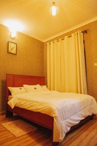una camera da letto con un grande letto con lenzuola bianche di Amarula Tree Hotel Mikumi a Mikumi