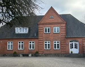 un edificio in mattoni rossi con finestre bianche e tetto di Vejbæk Domus a Padborg