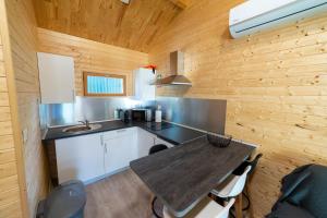 a kitchen with a wooden wall and a table at Chalet d'Aroeira in Corroios