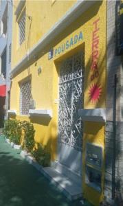 un edificio amarillo con una puerta a un lado en Pousada Terra do Sol, en Fortaleza