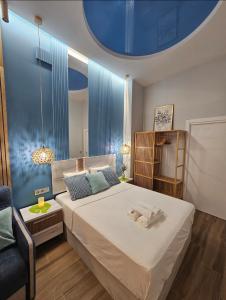 um quarto com uma cama grande e um tecto azul em Lounge garden sea relax em Valência