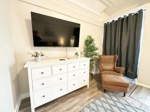 uma sala de estar com uma cómoda branca e uma televisão em Gorgeous Condo in SJ w Coffee Wi-FI em Saint John