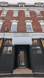 a large brick building with a black door at Gorgeous Condo in SJ w Coffee Wi-FI in Saint John