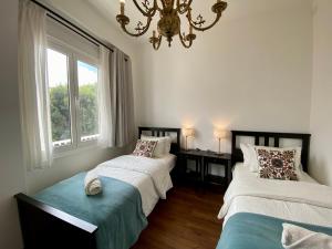 a bedroom with two beds and a chandelier at VISTA PLAZA - Exceptional Location in Los Llanos de Aridane