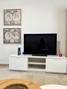 een wit entertainmentcentrum met een grote flatscreen-tv bij Fuengirola Sweet Apartament in Fuengirola