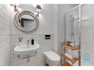 a bathroom with a sink and a toilet and a mirror at Libertas Premium Apartment at Old Town Gdansk in Gdańsk +13 photos