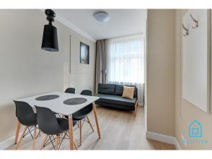 a dining room with a white table and chairs at Libertas Premium Apartment at Old Town Gdansk in Gdańsk