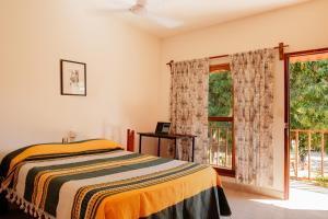 Schlafzimmer mit einem Bett und einem Fenster in der Unterkunft Casa Triz in Puerto Escondido