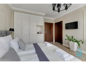 a bedroom with a large white bed with two pillows at Libertas Premium Apartment at Old Town Gdansk in Gdańsk